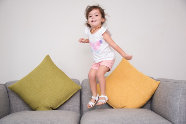 Petite fille qui saute sur un canapé qui s’affaisse